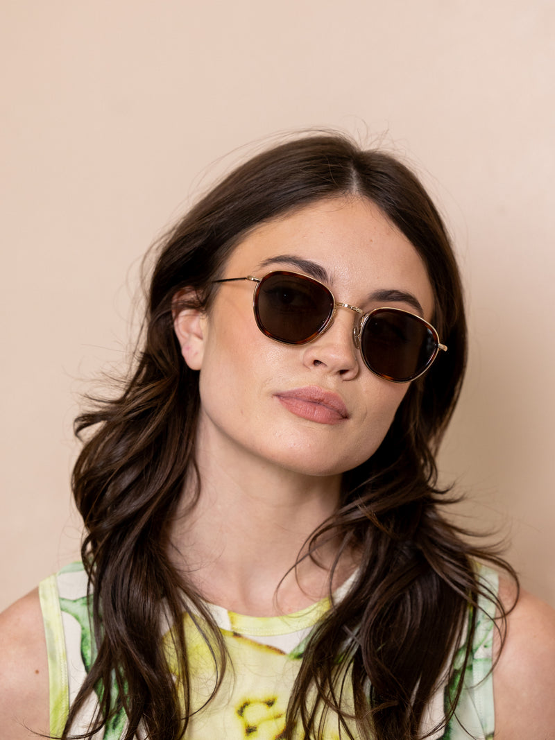 Woman wearing brown wireframe sunglasses.