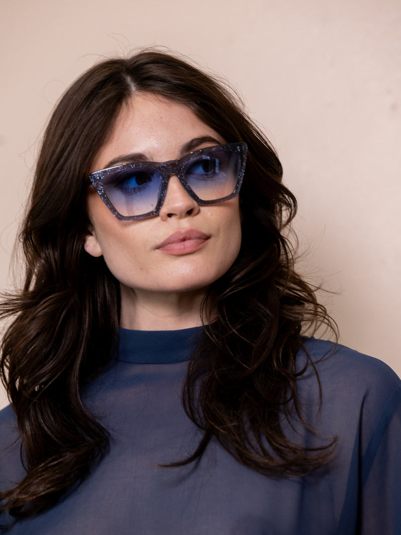Woman wearing blue angular sunglasses