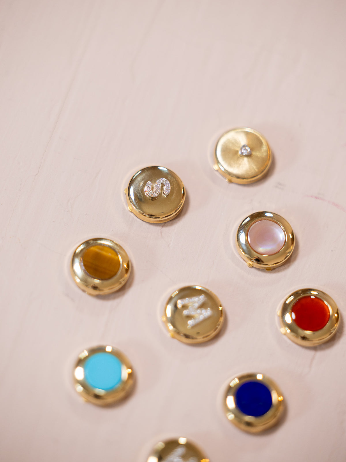 Multiple button covers on pink background.