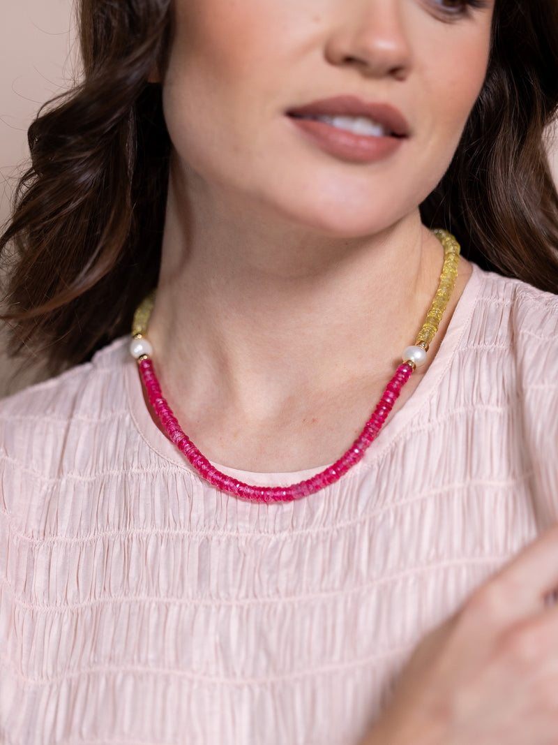 Woman wearing necklace with pearls and yellow and pink beads