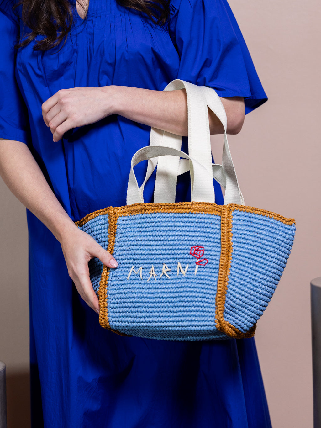 Woman in blue dress holding blue bag