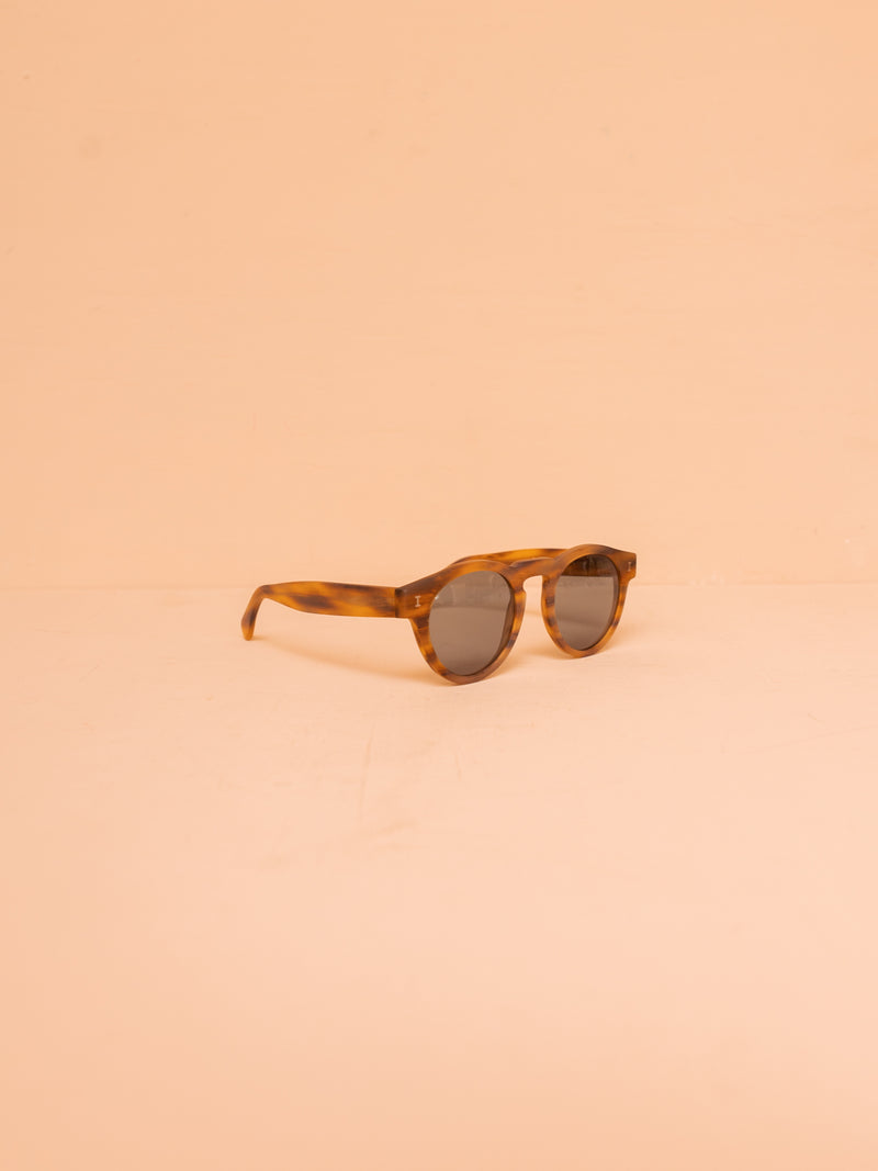 Brown sunglasses against pink background