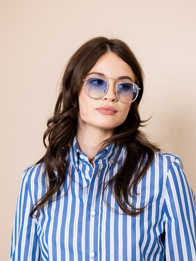 Woman wearing blue wireframe sunglasses.