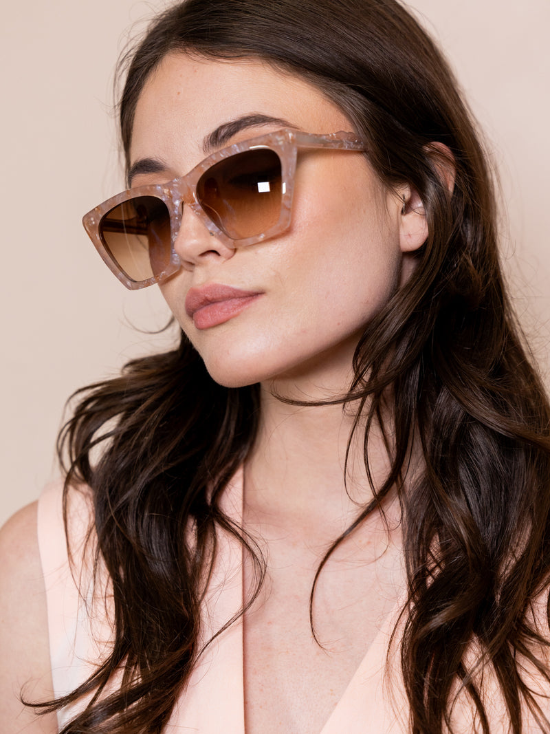 Woman wearing pink angular sunglasses