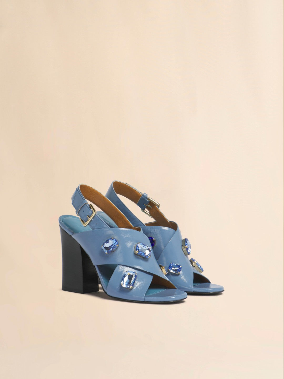 Blue heels with jewels against tan background