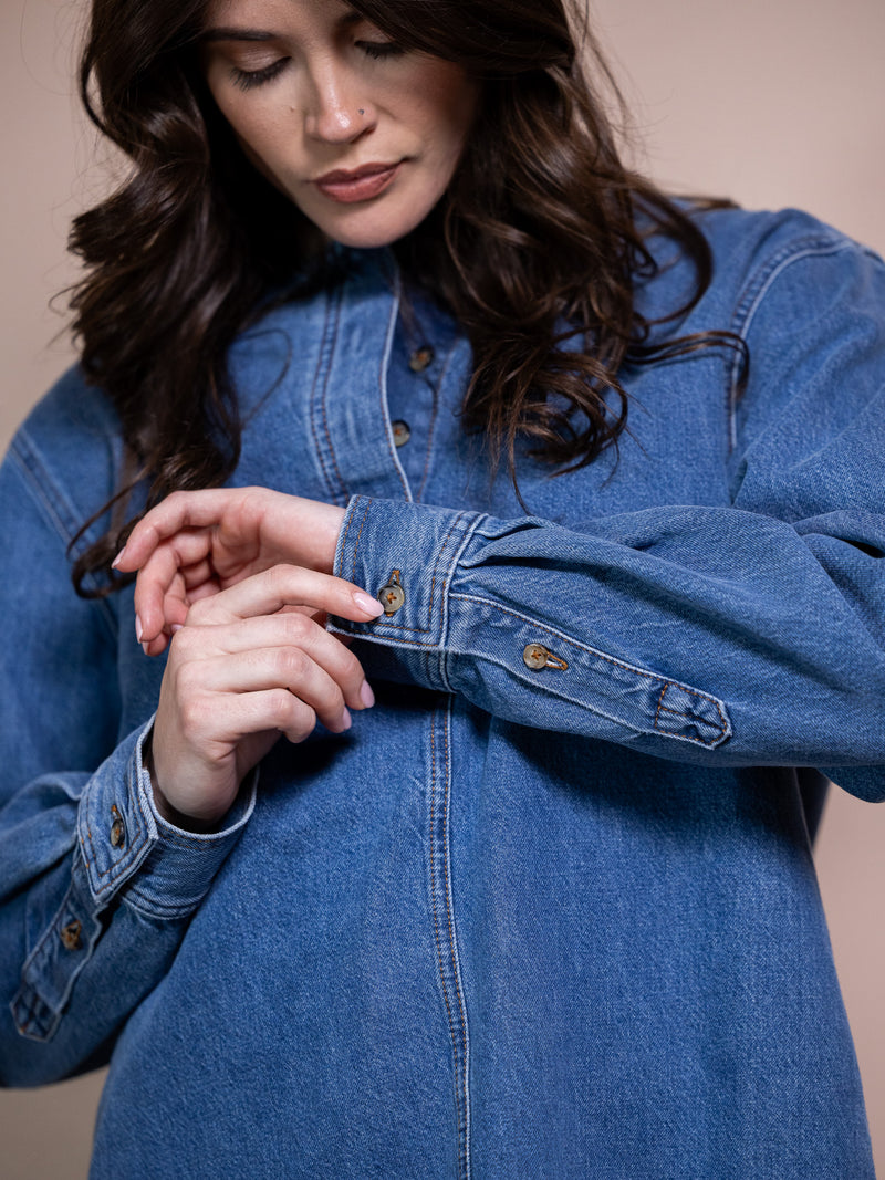 Woman in blue denim shirt against pink background
