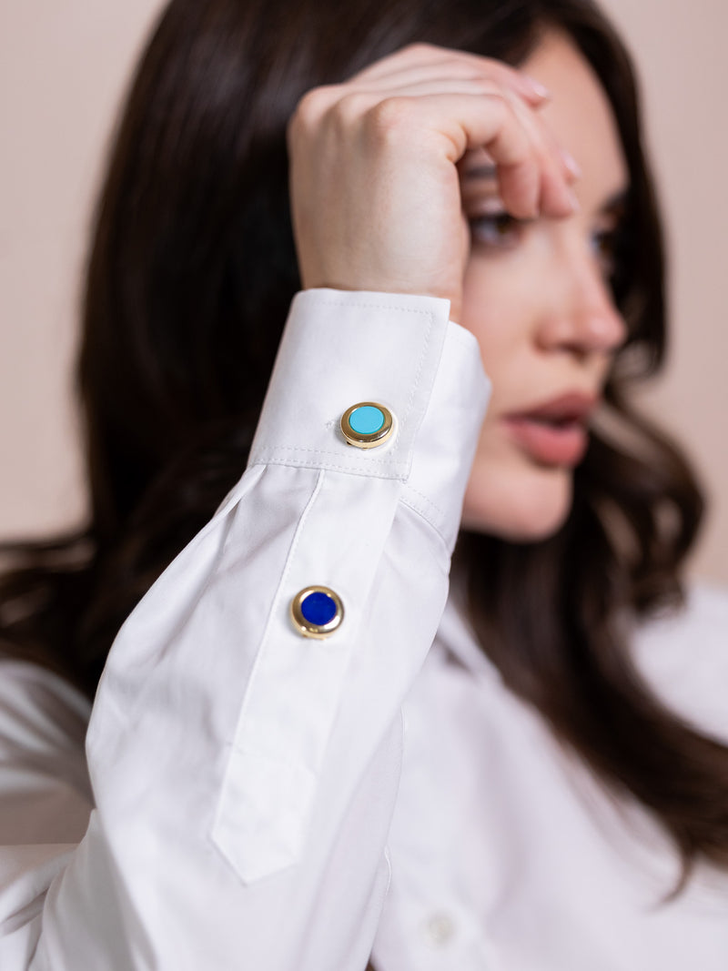 Turquoise and gold button cover on white shirt.