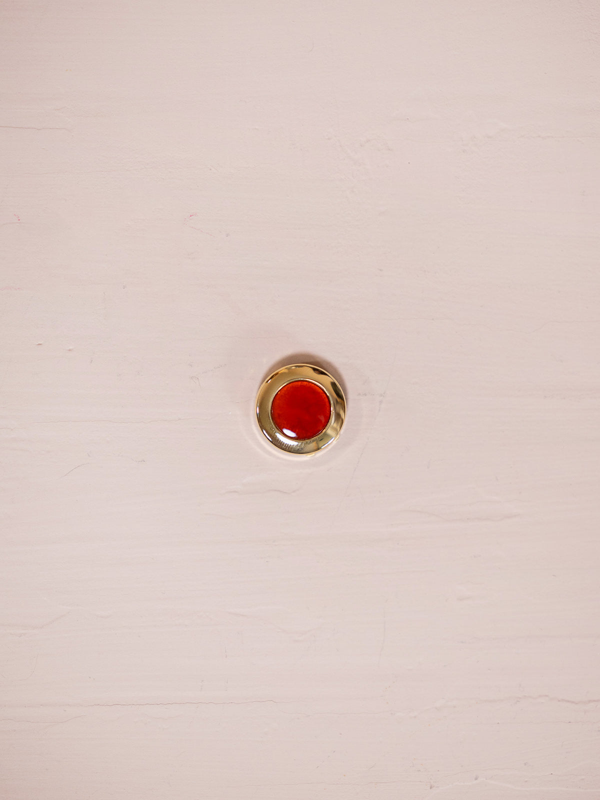 Cornelian and gold button cover  against pink background
