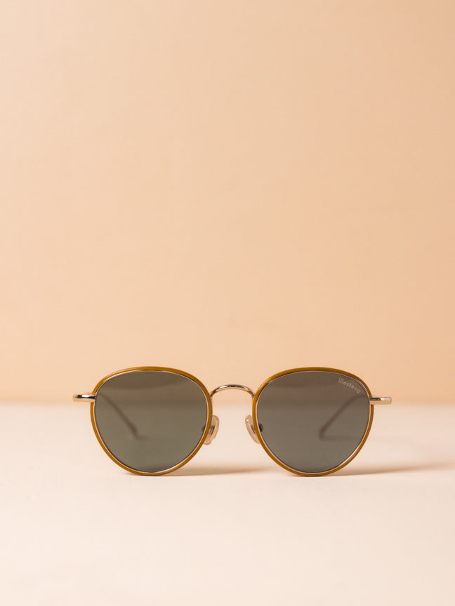 Illesteva wireframed sunglasses. They have a round frame and the lenses are circled by a brown frame, and the lenses are a light gray. Illesteva Jeffereson Ace in gold. 