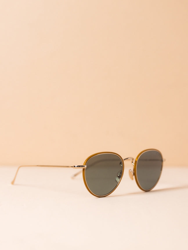 Style Number: Illesteva wireframed sunglasses. They have a round frame and the lenses are circled by a brown frame, and the lenses are a light gray. Illesteva Jeffereson Ace in gold.