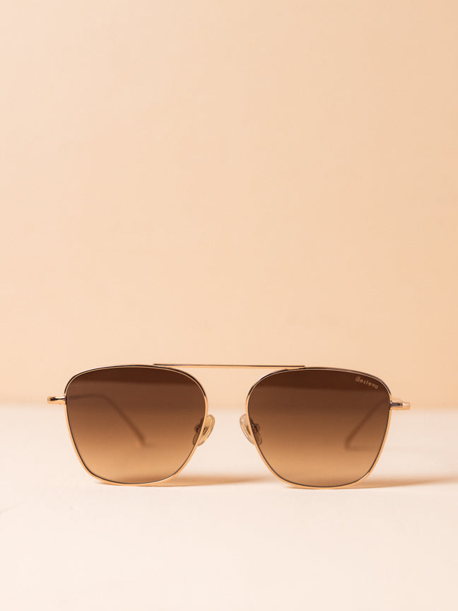 Illesteva wire framed sunglasses with a single bridge at the the brown and nose pads. The frames are a subtle rose gold and the lenses are a light brown ombre. Illesteva Samos sunglasses in rose gold. Style Number: SMO3BRFG