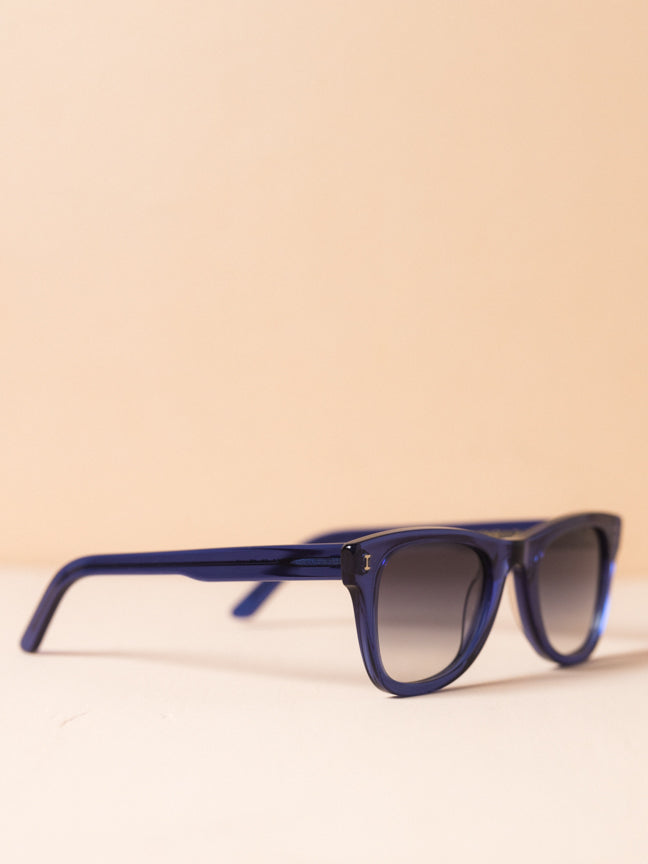 Side view of Illesteva sunglasses with rounded rectangular frames with blue frames and ombre lenses. Illesteva Austin in blue. Style Number: ILLESTEVA-AUS5GRFG